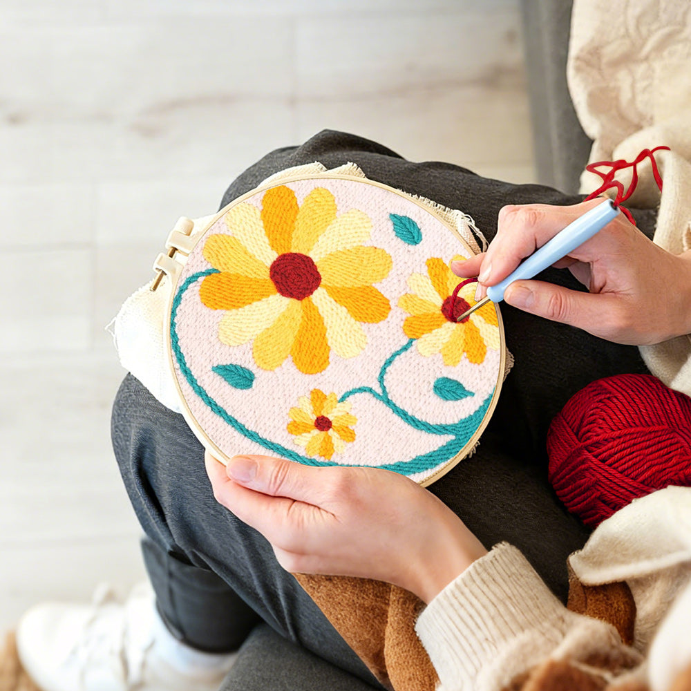 Creating handmade yellow daisies with teal vines punch needle artwork