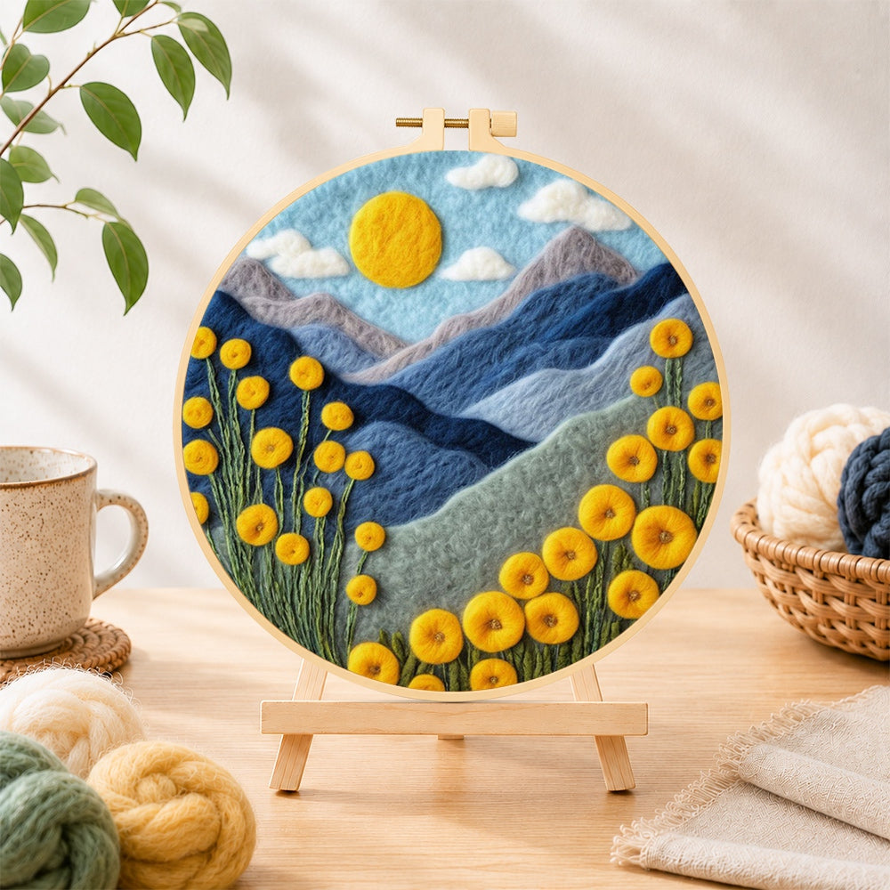Finished yellow flowers and blue mountains needle felting displayed on a wooden easel