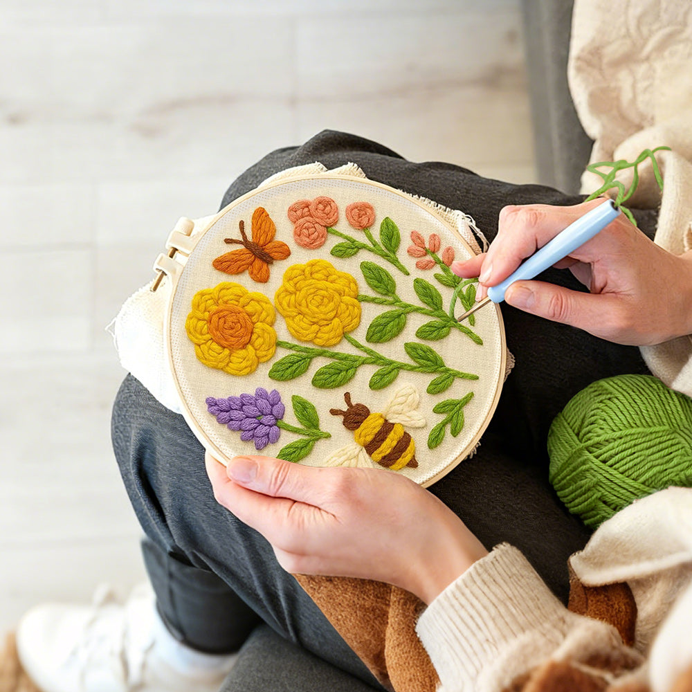 Creating handmade yellow flowers, butterfly and bee punch needle artwork