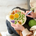 Creating handmade yellow flowers, butterfly and bee punch needle artwork