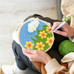 Creating handmade yellow flowers under a cloud punch needle artwork