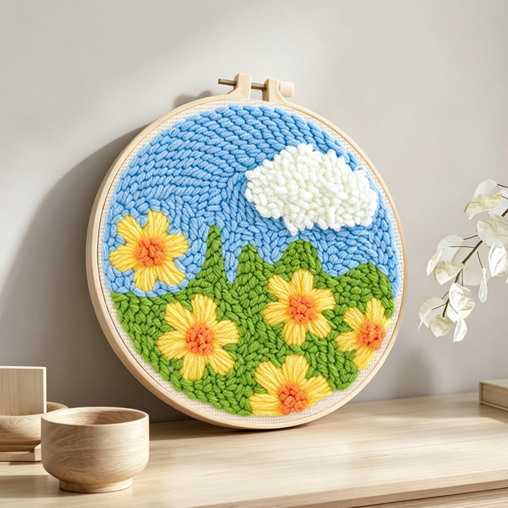 Yellow flowers under a cloud punch needle artwork displayed on a table