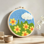 Yellow flowers under a cloud punch needle artwork displayed on a table