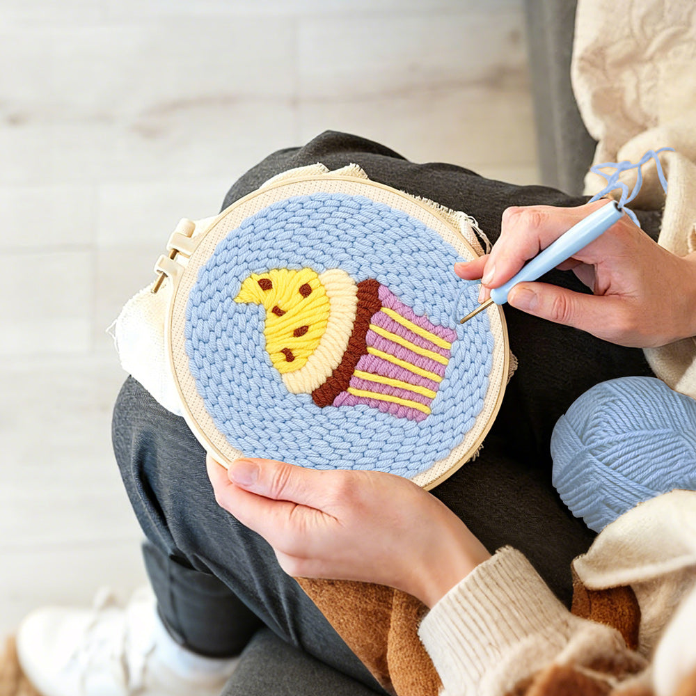 Creating handmade yellow frosting cupcake punch needle artwork