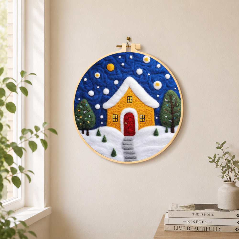 Yellow house with snowy path needle felt wall art displayed in a bright home interior