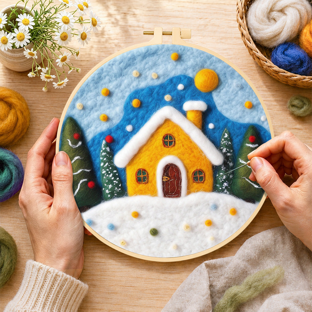 Creating the yellow snowy cottage at christmas wool painting by hand with a felting needle