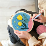 Creating handmade yellow tulips on pink hills punch needle artwork