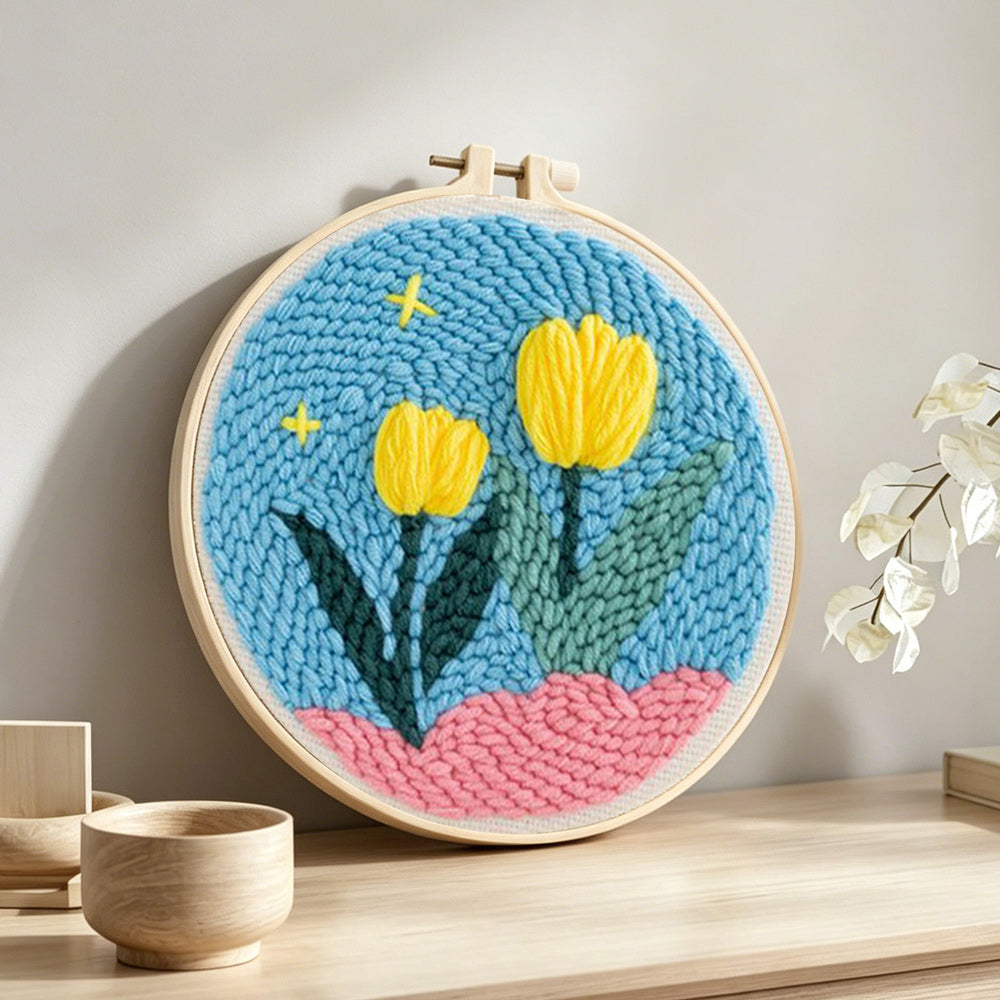 Yellow tulips on pink hills punch needle artwork displayed on a table