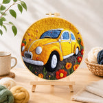 Finished yellow vintage car needle felting displayed on a wooden easel